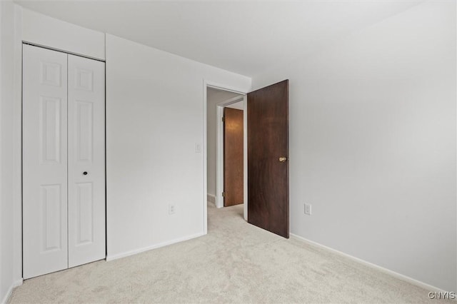 unfurnished bedroom featuring a closet, baseboards, and carpet flooring