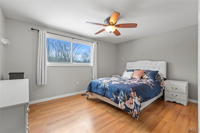 bedroom featuring a ceiling fan, light wood-type flooring, and baseboards