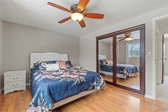 bedroom featuring wood finished floors, a ceiling fan, and baseboards