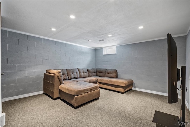 carpeted living area featuring concrete block wall, baseboards, and recessed lighting