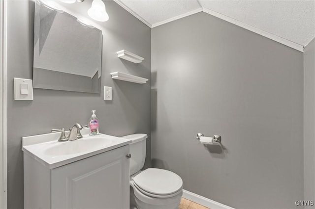 bathroom with baseboards, toilet, lofted ceiling, a textured ceiling, and vanity