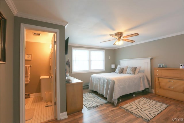 bedroom featuring crown molding, visible vents, baseboard heating, ensuite bathroom, and wood finished floors