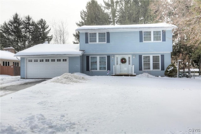 colonial home featuring aphalt driveway and an attached garage