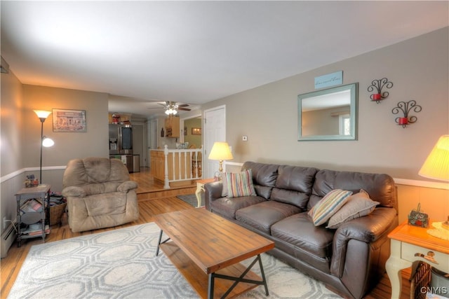 living area with ceiling fan and light wood finished floors