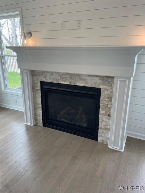 details with wooden walls, baseboards, wood finished floors, and a fireplace