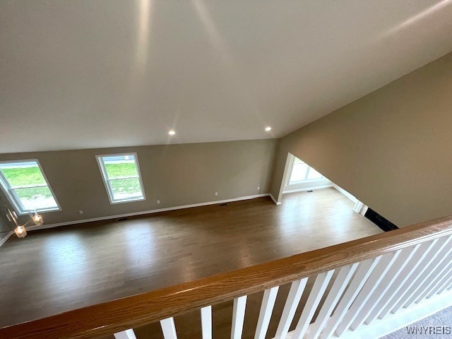 unfurnished living room with recessed lighting, baseboards, vaulted ceiling, and wood finished floors