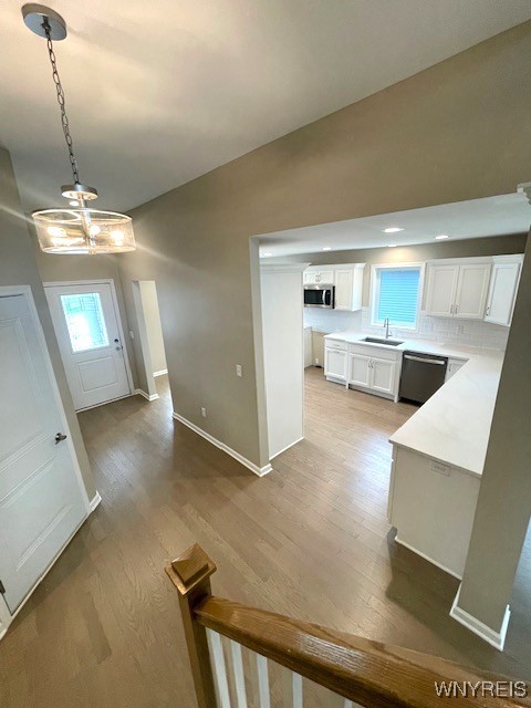 interior space featuring a sink, baseboards, and light wood-style flooring