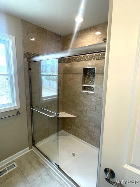 full bathroom featuring visible vents, baseboards, tile patterned flooring, and a shower stall