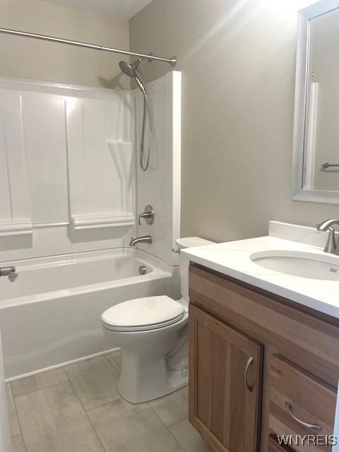 full bath featuring toilet, tile patterned floors,  shower combination, and vanity