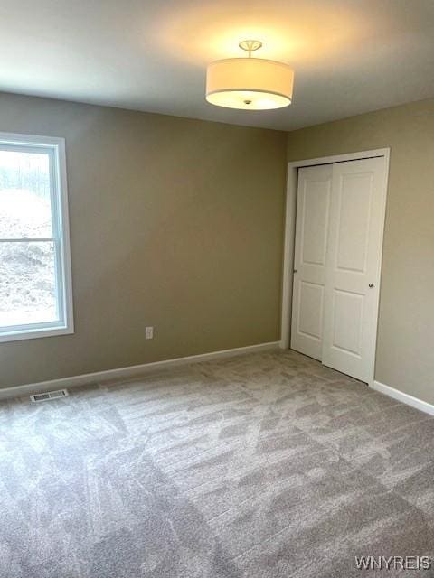 spare room featuring baseboards, carpet, and visible vents
