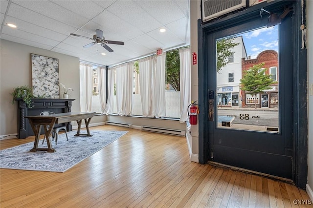 79-81 Main St, Sidney, NY 13838 - home office featuring a wall unit AC, a baseboard radiator, hardwood / wood-style floors, ceiling fan, and baseboards