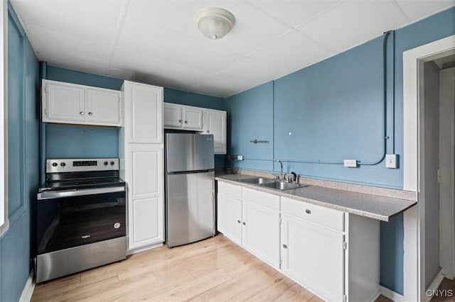 79-81 Main St, Sidney, NY 13838 - kitchen featuring light countertops, light wood-style flooring, appliances with stainless steel finishes, white cabinets, and a sink