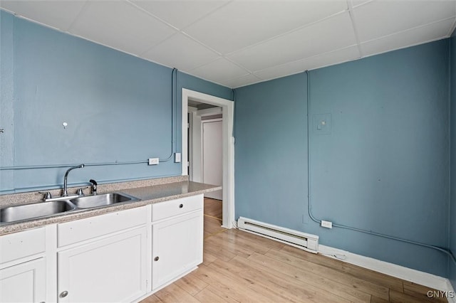 79-81 Main St, Sidney, NY 13838 - kitchen featuring baseboard heating, a sink, a paneled ceiling, and white cabinets