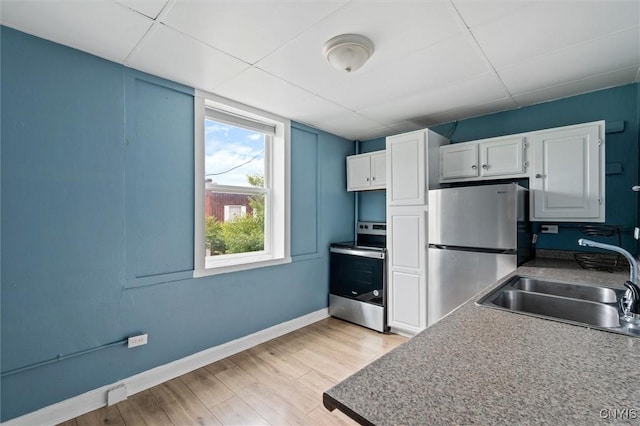 79-81 Main St, Sidney, NY 13838 - kitchen featuring baseboards, white cabinets, stainless steel appliances, light wood-type flooring, and a sink
