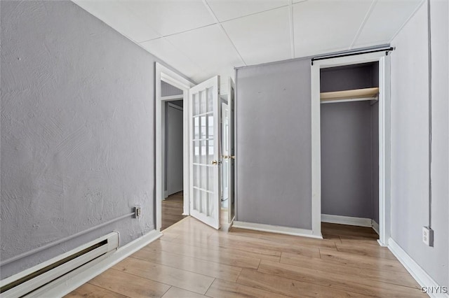 79-81 Main St, Sidney, NY 13838 - unfurnished bedroom featuring a baseboard radiator, a closet, a textured wall, wood finished floors, and baseboards