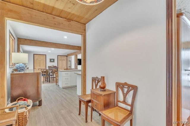 sitting room with light wood-style floors, wood ceiling, and beamed ceiling