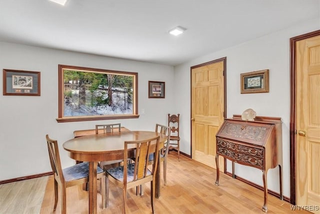 dining space featuring light wood finished floors and baseboards