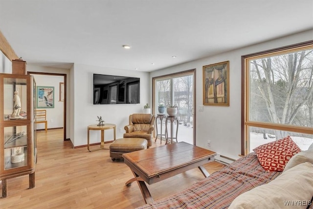 living room featuring light wood-type flooring, baseboards, baseboard heating, and recessed lighting