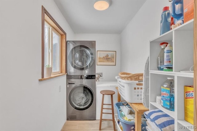 laundry area featuring stacked washer / dryer, laundry area, and wood finished floors