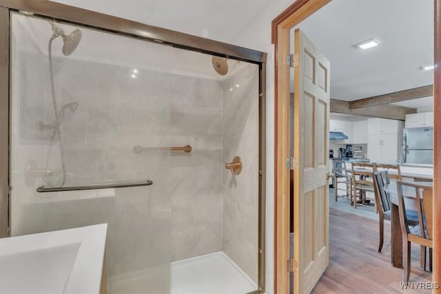 bathroom featuring wood finished floors and a shower stall