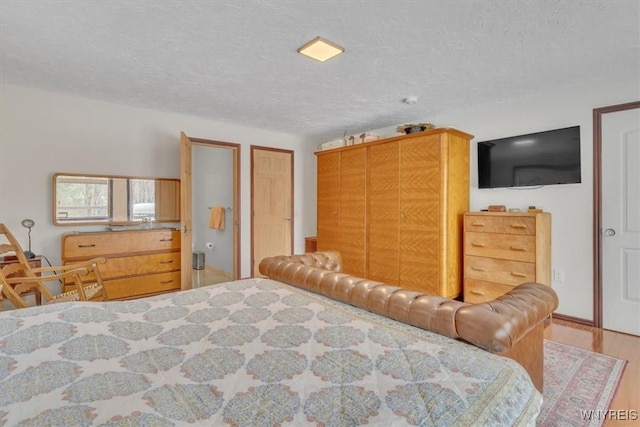 bedroom with a textured ceiling and wood finished floors