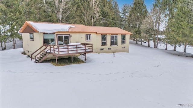 snow covered house featuring stairs, metal roof, crawl space, and a wooden deck