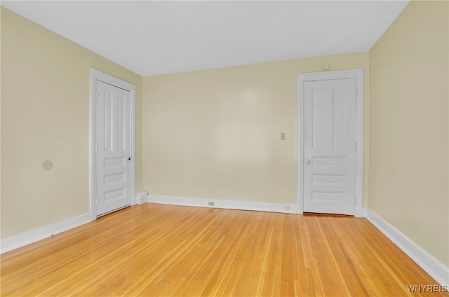 unfurnished room featuring baseboards and light wood finished floors