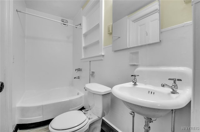 bathroom featuring toilet, tub / shower combination, and a sink