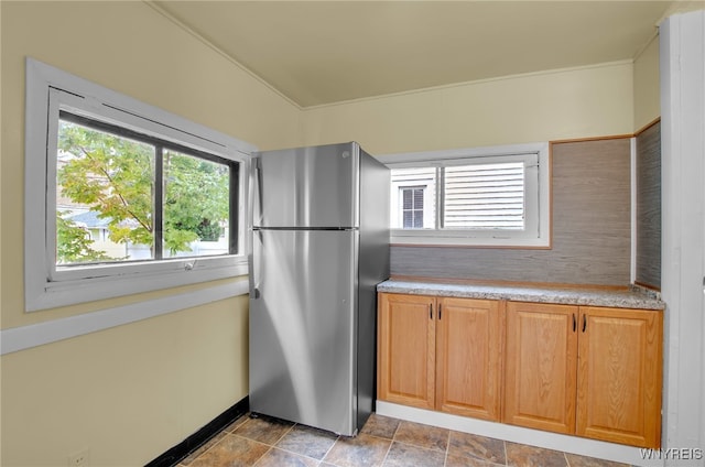 kitchen with light countertops, freestanding refrigerator, and stone finish flooring