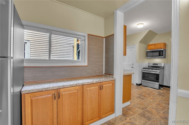 kitchen with stone finish floor, stainless steel appliances, and light countertops