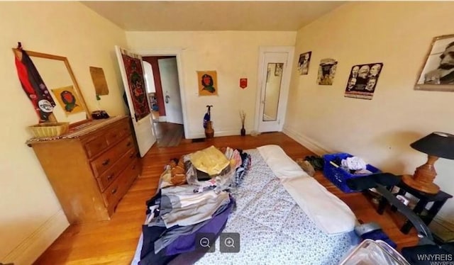 bedroom with baseboards and wood finished floors