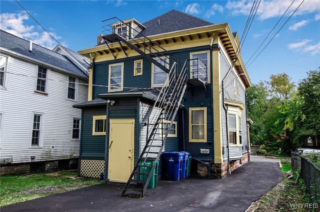 rear view of property with roof with shingles