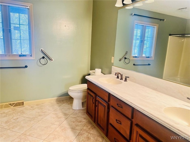 full bath featuring toilet, double vanity, a sink, and visible vents