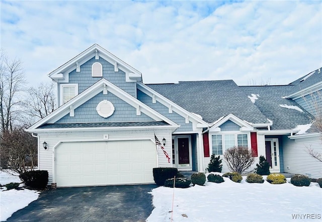 view of front of home featuring a garage, roof with shingles, and driveway