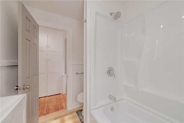 full bathroom with toilet, washtub / shower combination, and wood finished floors