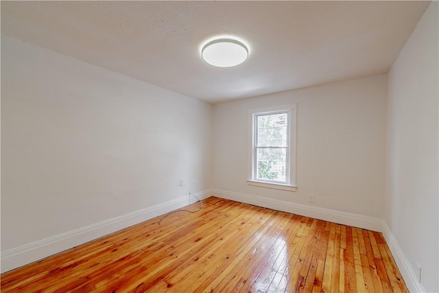 unfurnished room with light wood-style flooring and baseboards