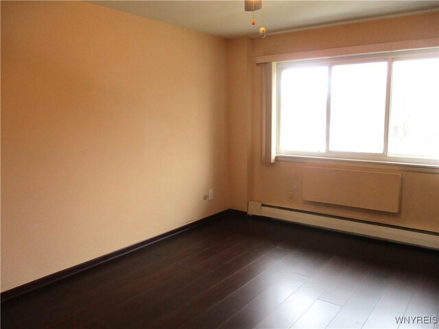 31 Park Lane Ct, Amherst, NY 14221 - empty room featuring a baseboard heating unit, dark wood-style floors, and baseboards