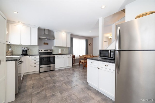 kitchen featuring stainless steel appliances, wall chimney exhaust hood, dark countertops, and decorative backsplash