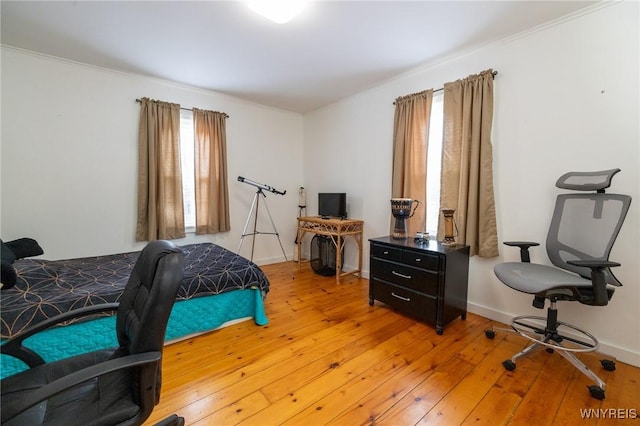 bedroom featuring ornamental molding, baseboards, and light wood finished floors