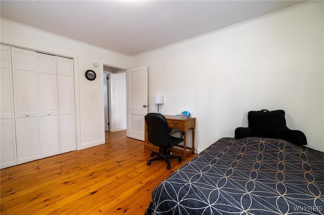 bedroom featuring ornamental molding, a closet, and light wood-style floors