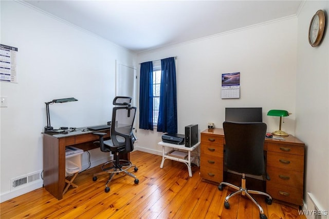 office area featuring ornamental molding, light wood finished floors, visible vents, and baseboards