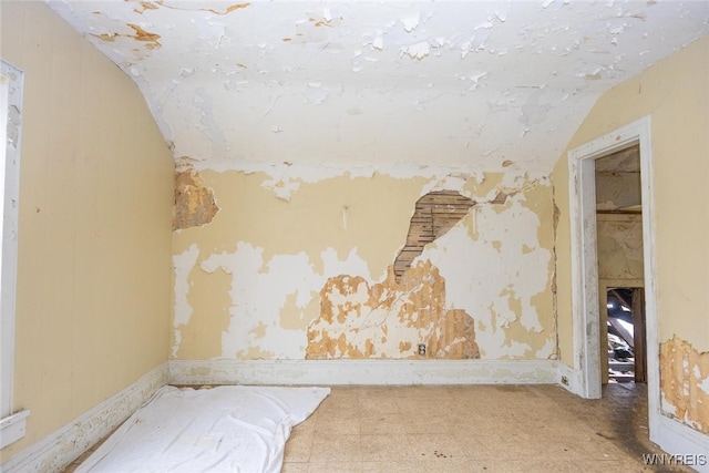 spare room with vaulted ceiling and baseboards