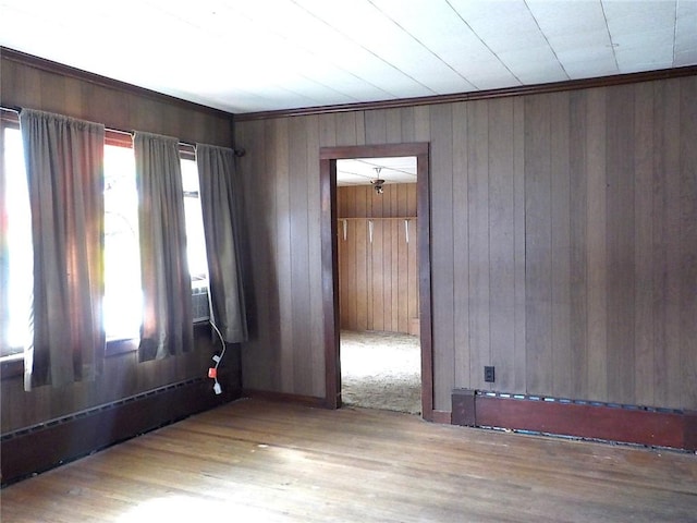 unfurnished room with a healthy amount of sunlight, wood walls, and wood finished floors