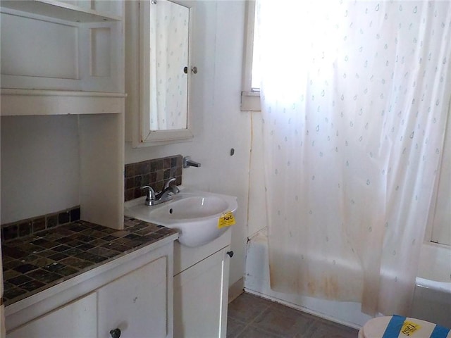 bathroom featuring tasteful backsplash, shower / bath combo, and vanity