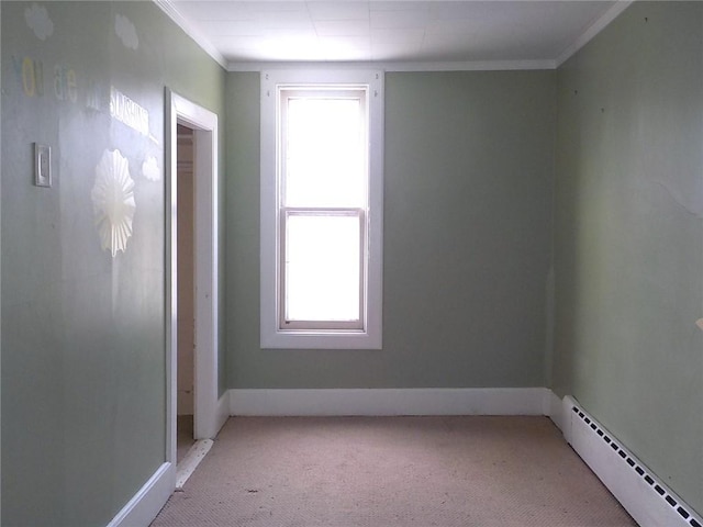 spare room with plenty of natural light, a baseboard heating unit, crown molding, and light colored carpet