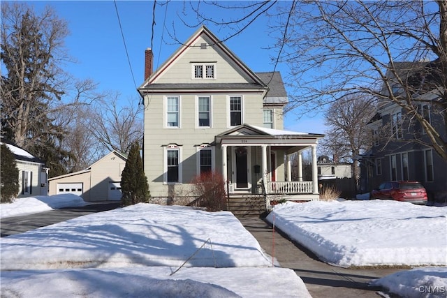 victorian-style house with a garage, covered porch, and a chimney