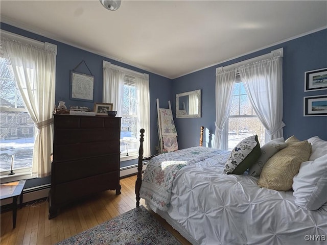 bedroom featuring crown molding, multiple windows, and hardwood / wood-style floors