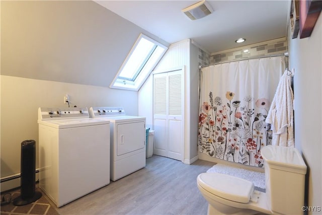 laundry room featuring laundry area, separate washer and dryer, a skylight, visible vents, and light wood-style floors