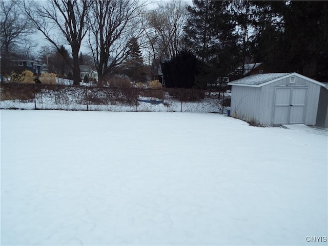 yard covered in snow with an outbuilding and a storage unit