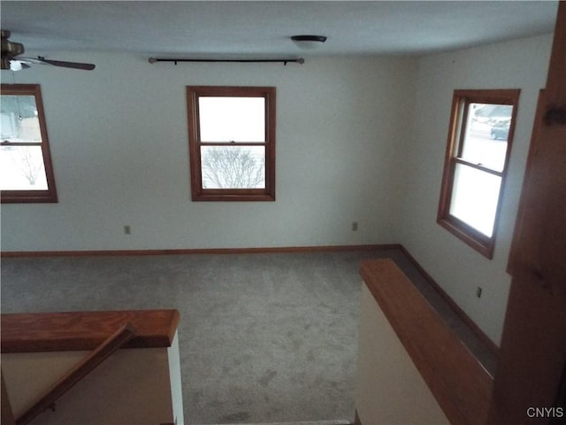 spare room with carpet, a healthy amount of sunlight, and baseboards